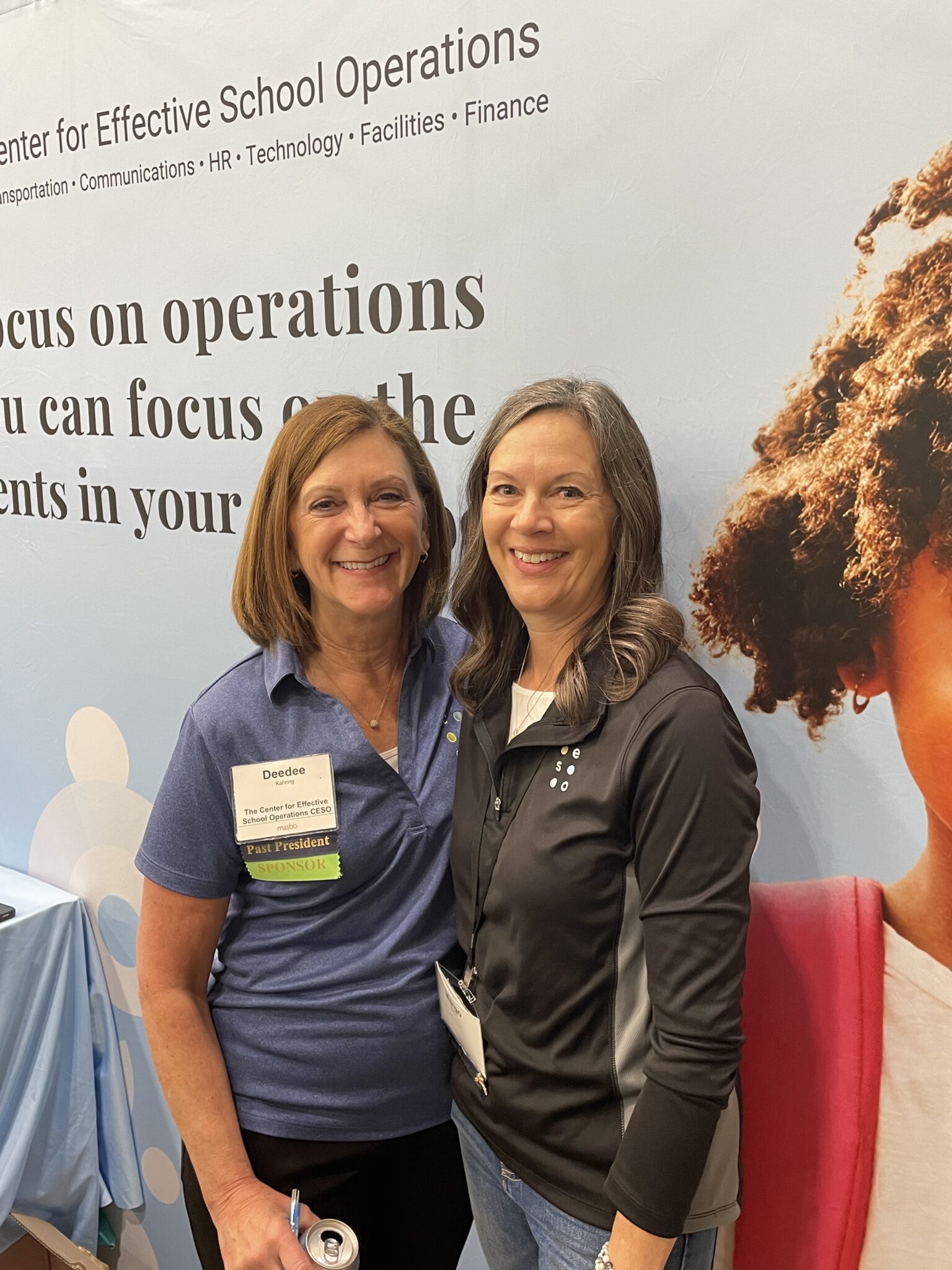two women in tradeshow booth at conference